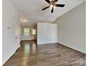 Open living room boasts laminate floors, vaulted ceiling with fan, and natural light filtering through the windows at 4328 Frank Vance Rd, Charlotte, NC 28216