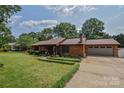 Well-maintained home with a spacious front yard, wood siding, and attached garage at 4920 Surfwood Dr, Sherrills Ford, NC 28673