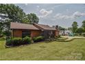 Side view of a wood-sided home with manicured front yard and mature trees in the background at 4920 Surfwood Dr, Sherrills Ford, NC 28673
