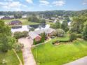 View of estate home with landscaped lawn, private pond, brick exterior, and lake access at 6823 Manatee Dr, Concord, NC 28025