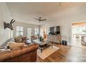 Bright living room featuring hardwood floors, neutral paint, a ceiling fan, and large windows with plantation shutters at 7901 Bud Henderson Rd, Huntersville, NC 28078