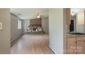 Open-concept living room featuring a brick fireplace, ceiling fan, and hardwood floors at 8019 Walnut Creek Ln, Charlotte, NC 28227