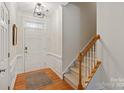 Bright foyer featuring hardwood floors, staircase, and stylish lighting, creating a welcoming entrance at 1003 Grayscroft Dr, Waxhaw, NC 28173