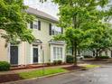 Charming townhome featuring light green siding, bay window, and a black front door, nestled beneath the shade of a mature tree at 13604 Morehouse St, Huntersville, NC 28078