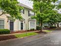 Charming townhome featuring light green siding, bay window, and a black front door, nestled beneath the shade of a mature tree at 13604 Morehouse St, Huntersville, NC 28078