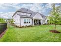 Beautiful backyard with a well-manicured lawn, covered patio, and dark metal fence at 13708 Huntson Park Ln, Huntersville, NC 28078