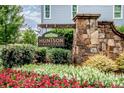 Huntson Reserve entrance sign with stone accents and colorful flower beds at 13708 Huntson Park Ln, Huntersville, NC 28078