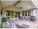 Covered patio with comfortable seating, ceiling fan, grill, and large sliding glass doors at 13708 Huntson Park Ln, Huntersville, NC 28078