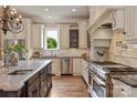 Gourmet kitchen featuring custom cabinetry, stainless steel appliances, and an elegant range hood with a professional stovetop at 1501 Alydar Ct, Waxhaw, NC 28173