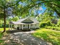 Beautiful one-story home boasts a covered porch, gravel driveway, and lush green lawn at 1528 Avondale Dr, Statesville, NC 28625
