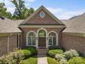 Elegant brick home entrance with arched windows and meticulous landscaping at 1629 Southpoint Ln, New London, NC 28127