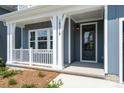 Inviting front porch with white columns and railings, leading to the home's entrance at 18019 Wilbanks Dr, Charlotte, NC 28278