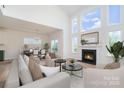 Bright living room with fireplace, large windows, and an adjacent dining area provides a cozy and inviting space at 18019 Wilbanks Dr, Charlotte, NC 28278