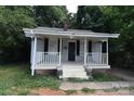 Charming home with a covered front porch with black shutters and gray vinyl siding at 2017 Ashley Rd, Charlotte, NC 28208