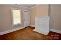 Inviting living area with hardwood floors and a painted brick fireplace, with natural light at 2017 Ashley Rd, Charlotte, NC 28208