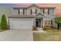 Inviting two-story home featuring a two-car garage, front porch, and beautifully landscaped front yard at 2037 Christopher Wood Ct, Fort Mill, SC 29707
