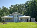 Charming home exterior featuring a light-colored facade, covered porches, and green lawn at 2905 Medlin Rd # 40 Acres, Monroe, NC 28112
