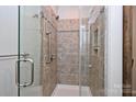 Tiled shower featuring glass door, and mosaic tile accent at 3014 Castleberry Ct, Charlotte, NC 28209