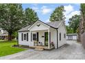 Quaint house with white siding, a metal roof, and a welcoming front porch with a small seating area at 310 S Jacob St, Cherryville, NC 28021