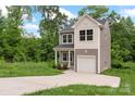 Charming two-story home featuring a gray and white exterior, attached garage, long driveway, and lawn at 510 3Rd St, Salisbury, NC 28144