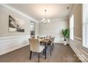 Formal dining room boasts wainscoting, hardwood floors, and a stylish chandelier at 5635 Agora Ct, Lancaster, SC 29720