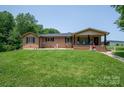 Charming brick home features a covered porch and lush front lawn, creating an inviting exterior at 5958 Hoover Elmore Rd, Lincolnton, NC 28092