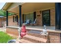 Welcoming front porch with comfortable seating, decorative columns, and brick accents offers a cozy outdoor space at 5958 Hoover Elmore Rd, Lincolnton, NC 28092