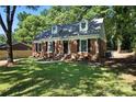 View of the front of a charming brick home with dormer windows and a well-manicured lawn at 6127 Eagle Peak Dr, Charlotte, NC 28214