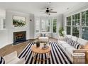 Bright, staged living room with fireplace, large windows, and stylish black and white accents at 7130 Founders Club Ct, Charlotte, NC 28269