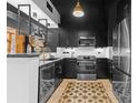 Modern kitchen features stainless appliances, black cabinets, quartz counters, and designer flooring at 720 Governor Morrison St # 219, Charlotte, NC 28211