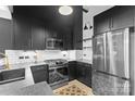 Stylish kitchen showcasing stainless steel appliances, dark cabinetry, and unique flooring design at 720 Governor Morrison St # 219, Charlotte, NC 28211