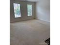 Bright bedroom with neutral carpet, two windows, and ample natural light at 9177 Bonnie Briar Cir, Charlotte, NC 28277