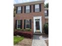 A close-up of the brick home's front entrance, showcasing a white trimmed doorway and decorative shrubs at 9177 Bonnie Briar Cir, Charlotte, NC 28277