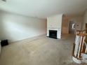 Spacious living room featuring a fireplace and staircase, perfect for Gathering gatherings at 9177 Bonnie Briar Cir, Charlotte, NC 28277