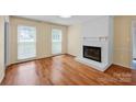 A spacious living room with hardwood floors and a brick fireplace is ready for your personal touch at 1006 Covewood Ct, Charlotte, NC 28270