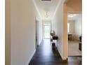 Bright hallway with dark hardwood floors, white trim, and a view of the front door at 1211 Calder Dr, Indian Trail, NC 28079