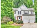 Charming two-story home with a beautifully landscaped yard, a brick entrance, and a two-car garage at 14203 Queens Carriage Pl, Charlotte, NC 28278