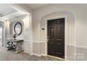 Hallway with arched entrance, decorative table with mirror, and dark front door marked '14307' at 14347 San Paolo Ln, Charlotte, NC 28277