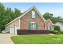 Charming brick home featuring green shutters, lush lawn, and a convenient two-car garage at 1575 Williamsburg Dr, Rock Hill, SC 29732