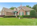 Attractive brick home with manicured landscaping, an American flag, and charming green shutters at 1575 Williamsburg Dr, Rock Hill, SC 29732