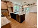 Open kitchen and living area featuring granite counters, stainless appliances, wood floors, and fireplace at 1721 S New Hope Rd, Gastonia, NC 28054