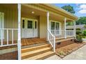 Close-up of the front entrance, showcasing a charming porch with wood stairs and a white front door at 336 Oakwood Dr, Mount Holly, NC 28120