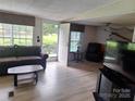 Cozy living room with neutral paint, laminated floors, and large windows at 5022 Wrenn Dr, Denver, NC 28037