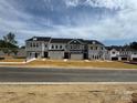 New townhomes under construction featuring a modern design with private garages and newly installed landscaping at 507 Webster Ln, Cramerton, NC 28032