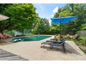 Relaxing backyard with a sparkling pool, patio furniture, and lush greenery at 6313 Weddington Rd, Concord, NC 28027