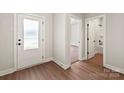 Bright entryway featuring wood-look flooring, a glass-paneled front door, and white trim at 7217 Jerimoth Dr, Charlotte, NC 28215