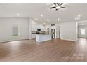 Spacious open-concept living area featuring wood-look flooring, a kitchen island, and modern appliances at 7217 Jerimoth Dr, Charlotte, NC 28215