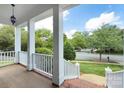 Inviting front porch with white pillars and railings offers a serene outdoor space with neighborhood views at 8044 Hawk Crest Ct, Charlotte, NC 28270