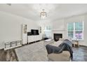 Bright living room featuring hardwood floors, fireplace, and natural light at 10135 Blakeney Preserve Dr, Charlotte, NC 28277