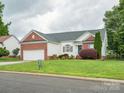 Well-maintained single Gathering home with attached two car garage, manicured lawn, and brick accents at 116 Birchwood Ct, Mount Holly, NC 28120